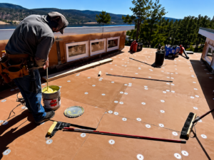 Roof leak repair process on a flat roof in Brooklyn showing damage and sealing work
