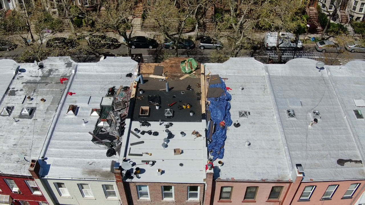 Brooklyn brownstone flat roof with water pooling and leak damage